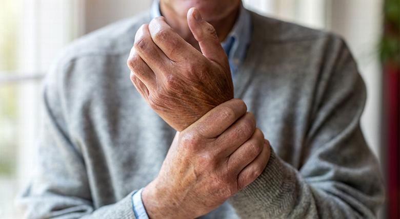 Man with arthritis holding wrist